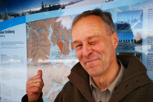 Feldberg-Ranger Achim Laber vor der Tafel zum Naturschutzgebiet Feldberg im Winter.  NAZ Sdschwarzwald